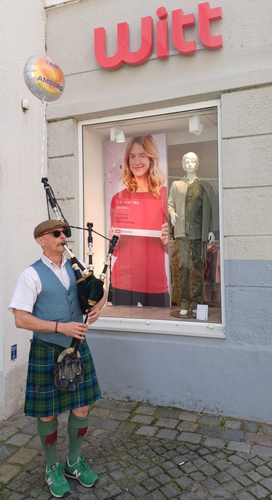 Dudelsackspieler und Dudelsacklehrer Roland Jezussek mit der Great Highland Bagpipe vor der Witt-Filiale in Amberg